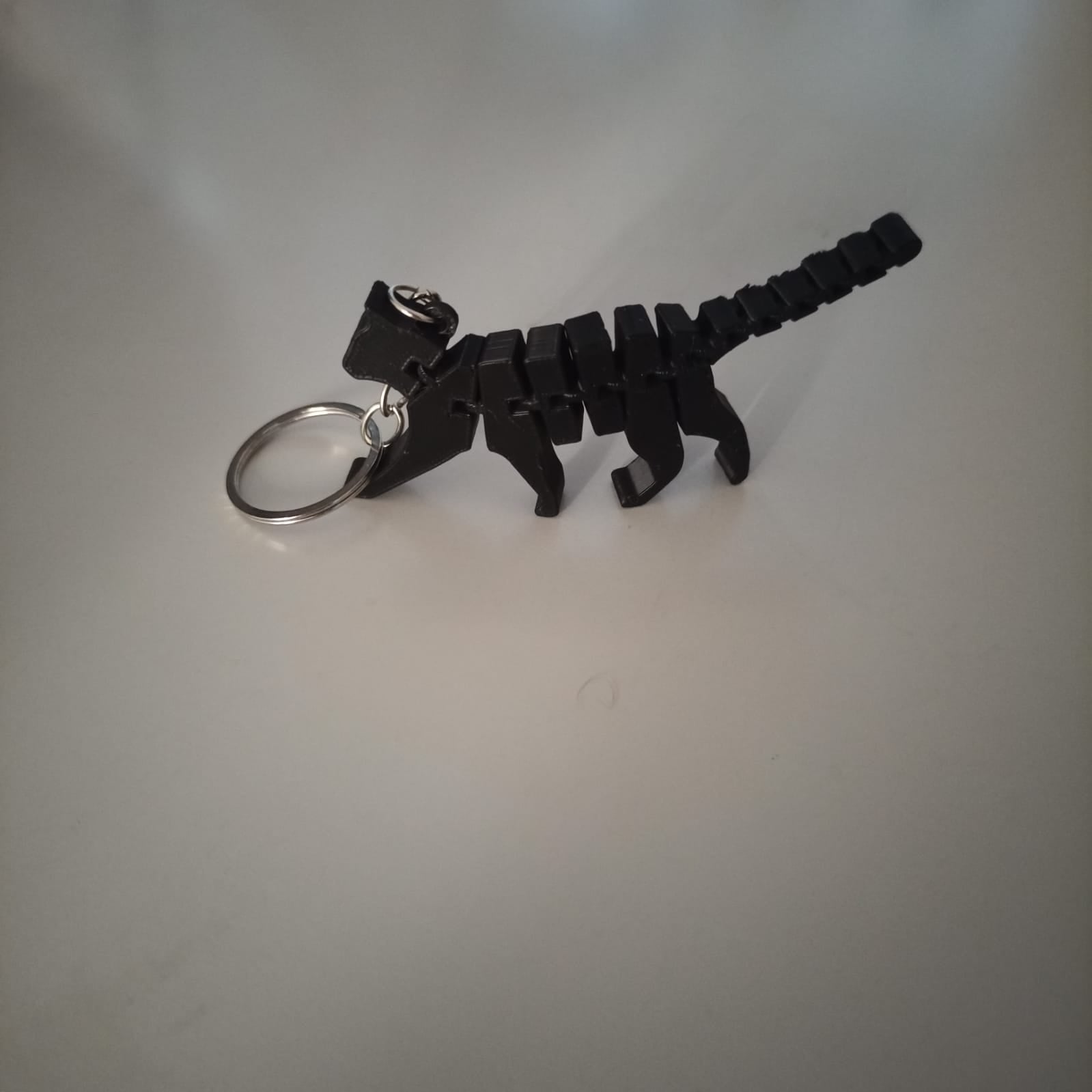 Chaveiro gato articulado impresso em 3D em ângulo lateral, destacando a cauda flexível
