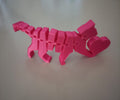 Gato articulado rosa impresso em 3D com filamento PLA, vista lateral mostrando corpo segmentado e coração na traseira
